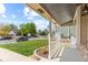 Charming front porch with white railing overlooking the landscaped front yard at 13244 Quivas St, Denver, CO 80234