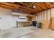 Spacious garage with exposed wooden beams, built-in shelving, and ample storage space at 13244 Quivas St, Denver, CO 80234