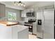 Updated kitchen with stainless steel appliances, light gray cabinets, and natural light at 13244 Quivas St, Denver, CO 80234