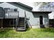 Rear exterior view featuring back entrance, stairs to an elevated deck, and grass at 8832 Lipan St, Thornton, CO 80260