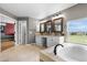Bright bathroom with double sinks, granite countertops, a soaking tub, and a view at 446 Angus Way, Highlands Ranch, CO 80129