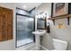Modern bathroom featuring a tiled shower, pedestal sink, and wood accents at 446 Angus Way, Highlands Ranch, CO 80129