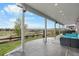 A covered patio boasts a stone floor, outdoor fireplace and seating, and views of the surrounding yard and mountains at 446 Angus Way, Highlands Ranch, CO 80129