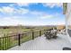 This deck has tables, chairs, and views of the green yard, homes, and distant mountains at 446 Angus Way, Highlands Ranch, CO 80129