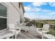 A deck features ample seating with chairs and chaise lounge with views of the surrounding area at 446 Angus Way, Highlands Ranch, CO 80129