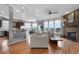 Open-concept living area with hardwood floors, brick fireplace, bar seating, and lots of natural light at 446 Angus Way, Highlands Ranch, CO 80129