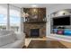 Inviting living room featuring a stone fireplace and hearth and lots of natural light from large windows at 446 Angus Way, Highlands Ranch, CO 80129