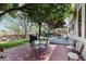 Serene backyard featuring a brick patio, mature trees, and lush greenery for outdoor relaxation at 1089 E 131St Dr, Thornton, CO 80241