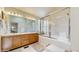 Bathroom includes a double sink vanity, a large mirror, and a glass-enclosed shower/tub at 1089 E 131St Dr, Thornton, CO 80241