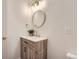 Modern bathroom featuring wood cabinet vanity, a round mirror, and gold hardware at 5720 E Caley Ave, Centennial, CO 80111