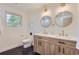 Double sink bathroom features dual wood vanities and black tile flooring at 5720 E Caley Ave, Centennial, CO 80111