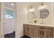 Double sink bathroom features dual wood vanities and black tile flooring at 5720 E Caley Ave, Centennial, CO 80111
