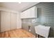 Well-equipped laundry room boasts updated cabinets, sink, and modern design at 5720 E Caley Ave, Centennial, CO 80111