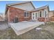 Brick exterior featuring a concrete patio and manicured lawn at 11197 W 64Th Pl, Arvada, CO 80004