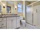 Bathroom featuring granite countertop, white cabinets, and glass enclosed shower with black and white tile floors at 11197 W 64Th Pl, Arvada, CO 80004