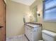 Bathroom featuring granite countertop, white cabinets, black and white floors, and a modern design at 11197 W 64Th Pl, Arvada, CO 80004