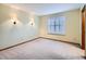 Empty bedroom featuring carpet floors, window with shutters, sconce lighting, and neutral paint at 11197 W 64Th Pl, Arvada, CO 80004