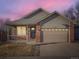 Charming single-Gathering home featuring a brick facade, covered porch, and a two-car garage at 11197 W 64Th Pl, Arvada, CO 80004