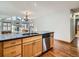 Open concept kitchen with wood cabinets, stainless steel dishwasher and sink, adjacent to a dining area at 11197 W 64Th Pl, Arvada, CO 80004