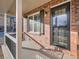 Cozy front porch featuring brick detail, black shutters, and a storm door at 11197 W 64Th Pl, Arvada, CO 80004