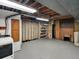 Unfinished basement with open ceiling features a laundry area, utility hookups, and storage at 6943 Ingalls St, Arvada, CO 80003