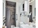 Modern bathroom features tile shower with safety bar, mirrored cabinet, and a sleek white vanity at 6943 Ingalls St, Arvada, CO 80003