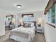 Bright bedroom featuring carpet floors, neutral colors, two windows, and mirrored closet doors at 6943 Ingalls St, Arvada, CO 80003