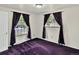 Bedroom with purple carpet features two windows dressed in dramatic purple drapes at 6943 Ingalls St, Arvada, CO 80003