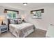 Bright bedroom featuring carpet floors, neutral colors, two windows, and side tables at 6943 Ingalls St, Arvada, CO 80003