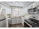 Bright, white modern kitchen with stainless steel appliances and stone countertops at 1221 Illinois St # 2E, Golden, CO 80401