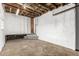Unfinished basement with exposed wooden beams, concrete floors and white walls at 367 S Jasmine St, Denver, CO 80224
