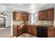 Functional kitchen with wooden cabinets, tile backsplash, black appliances, and tile floors at 367 S Jasmine St, Denver, CO 80224