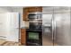 Kitchen with stainless steel refrigerator and oven, black range top and microwave, and wood cabinets at 367 S Jasmine St, Denver, CO 80224