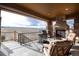 Spacious covered back porch featuring stone fireplace and panoramic views at 10751 Manorstone Dr, Highlands Ranch, CO 80126