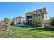 Beautiful backyard featuring a lush lawn and tiered landscaping and stone-clad architecture at 10751 Manorstone Dr, Highlands Ranch, CO 80126