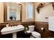 Elegant bathroom features a pedestal sink, tiled accents, and shuttered windows for natural light at 10751 Manorstone Dr, Highlands Ranch, CO 80126