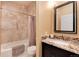 Bright bathroom featuring tile surround, dark vanity, and granite countertops at 10751 Manorstone Dr, Highlands Ranch, CO 80126