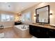 Primary bath with a luxurious tub, double sink vanity, and large framed mirrors at 10751 Manorstone Dr, Highlands Ranch, CO 80126