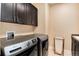 Bright laundry room featuring modern machines and sleek, dark cabinets at 10751 Manorstone Dr, Highlands Ranch, CO 80126