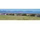 Scenic view from a grassy hill of nearby homes and mountains in the background at 10751 Manorstone Dr, Highlands Ranch, CO 80126