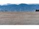 Scenic view of a dry field with fence below snow-covered mountains at 10751 Manorstone Dr, Highlands Ranch, CO 80126