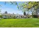 Lush backyard with a covered patio, beautiful lawn, and mature trees at 21 Fairway Ln, Littleton, CO 80123