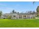 Inviting backyard with covered porch, dining and sitting areas, and manicured lawn at 21 Fairway Ln, Littleton, CO 80123