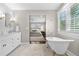 Elegant bathroom with a soaking tub and marble floors, flowing into the carpeted bedroom at 21 Fairway Ln, Littleton, CO 80123