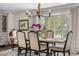 A sunlit dining room features a rustic table set, complemented by an elegant chandelier and scenic outdoor views at 21 Fairway Ln, Littleton, CO 80123