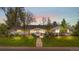 Stunning single story home with warm interior lights, mature trees, and a walkway to the front door at twilight at 21 Fairway Ln, Littleton, CO 80123