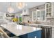 Kitchen featuring a white countertop island with barstool seating, stainless steel appliances and a white brick backsplash at 21 Fairway Ln, Littleton, CO 80123
