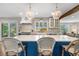 Bright kitchen with an island featuring barstool seating, pendant lighting, and a view to the fireplace and television at 21 Fairway Ln, Littleton, CO 80123