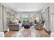 Bright and airy living room with a large sectional sofa, a floral area rug and views of the well-manicured backyard at 21 Fairway Ln, Littleton, CO 80123