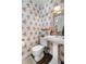 Charming powder room featuring unique peacock-themed wallpaper and a classic pedestal sink at 21 Fairway Ln, Littleton, CO 80123